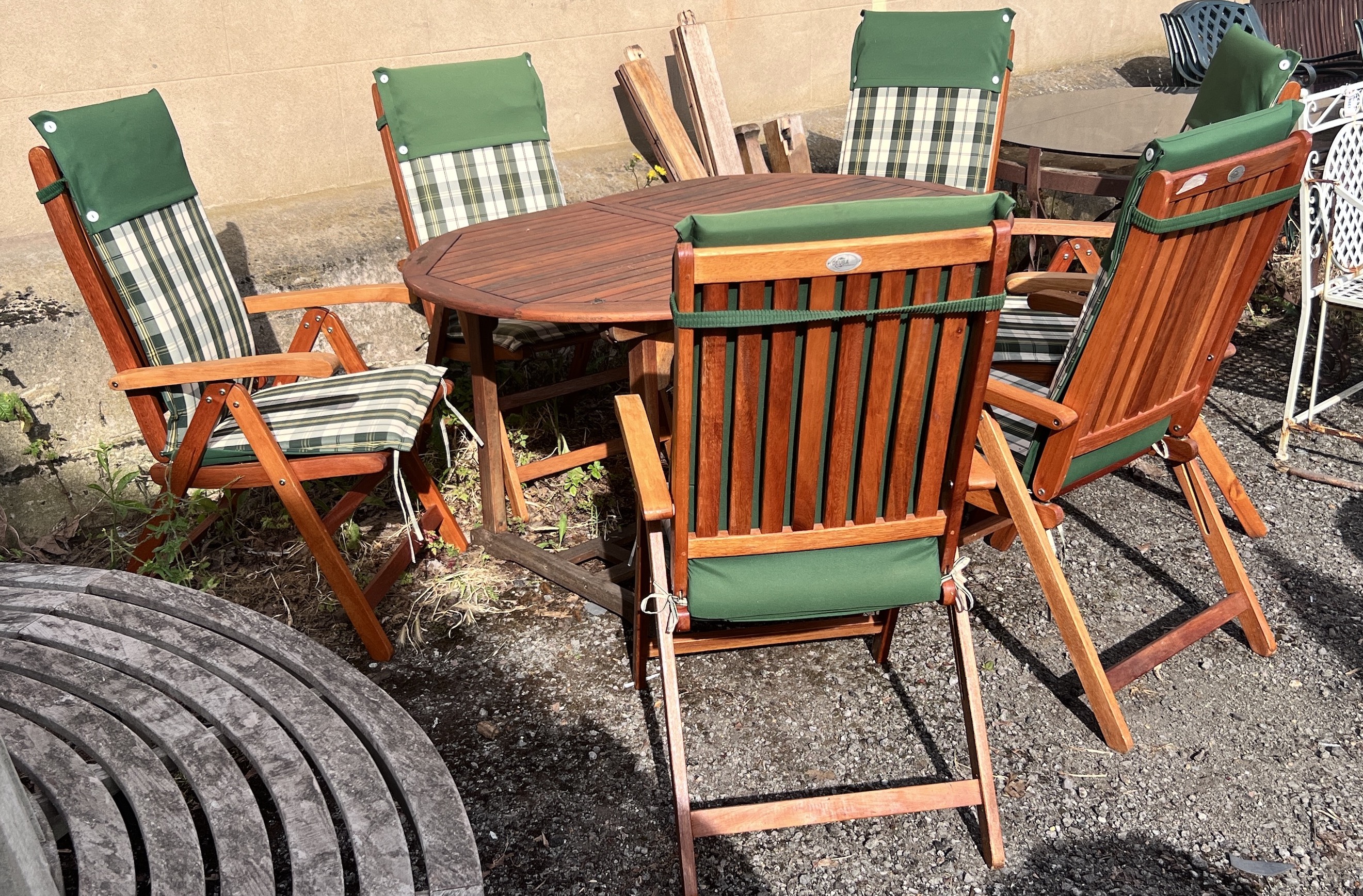 A stained teak extending garden table, length 150cm, depth 100cm, height 76cm, together with six Deuba teak folding garden chairs with cushions